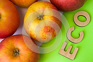 Apples as ECO food. Apples are on white background with text eco of wooden letters on green. Example of sustainable environmentall