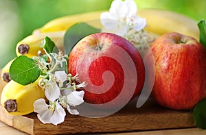 Apples and bananas on green background