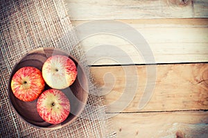 Apples in basket on wooden table