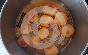 Apples boiling with sugar and cinamon cooking