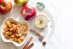 Apples, cinnamon and chunky applesauce on white background