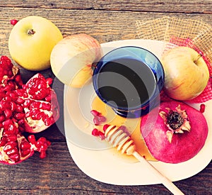 Apples, cut red pomegranate and honey. Jewish New Year Holiday, Rosh Hashanah food symbols on the old wood