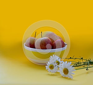 Apples and daisies on a bright background.