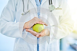 Apples are extremely rich in important antioxidants. Closeup shot of an unidentifiable doctor holding an apple in her