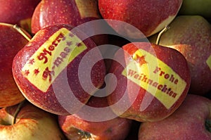 Apples with happy christmas wishes in two languages