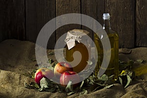 Apples with a jar of honey and a bottle of olive oil