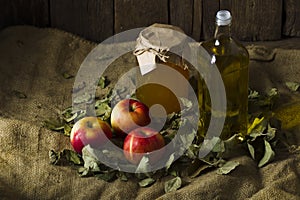 Apples with a jar of honey and a bottle of olive oil