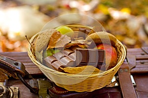 Apples, oatmeal cookies, chocolate in the basket in the autumn p