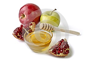 Apples, pomegranate and bowl of honey