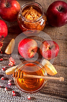 Apples, pomegranate and honey on the rustic wooden table