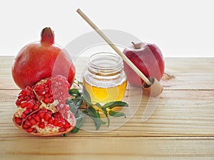 Apples, pomegranates and honey on the wooden board with the concept food selected at the Jewish holiday rosh hashanah.