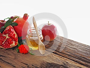 Apples, pomegranates and honey on the wooden board with the concept food selected at the Jewish holiday rosh hashanah.