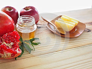 Apples, pomegranates and honey on the wooden board with the concept food selected at the Jewish holiday rosh hashanah.