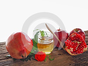 Apples, pomegranates and honey on the wooden board with the concept food selected at the Jewish holiday rosh hashanah.