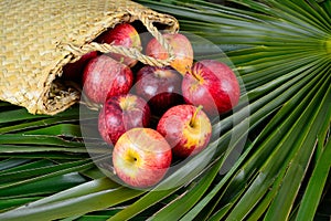 Apples spilling out of a hand woven flax bag