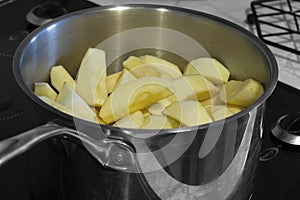 Apples stewing in a saucepan on a hob stove.