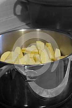 Apples stewing in a saucepan on a hob stove.