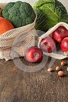 Apples and vegetables in ecological reusable mesh bags made of organic cotton