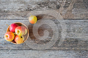 Apples in a wood bowl on wooden background.