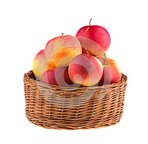Apples in a wooden basket isolated on white background. Vegetarian.