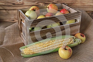 Apples in a wooden box, corn, healthy food, vegetables.