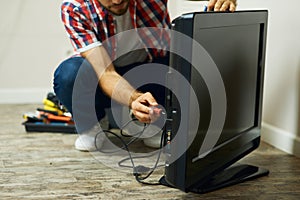 Appliance service. Cropped shot of repairman using a screwdriver while installing or fixing tv set indoors