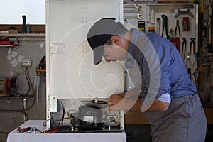 Appliance service technician in his workshop repairing a faulty refrigerator. Technician at work