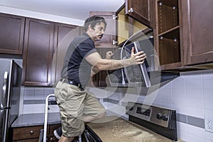 Appliance technician installing a microwave photo