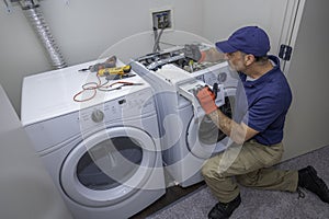 Appliance technician working on a front load washing machine in a laundry room