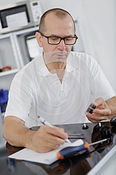 Appliance technician writing notes