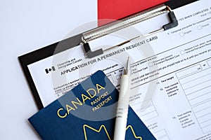 Application for permanent resident card on table with pen and canadian passport