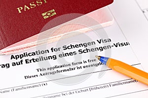 Application for Schengen visa, passport and pen.