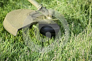 Application trimmers. Mowing green grass using a fishing line trimmer