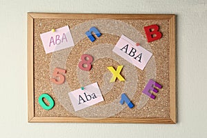 Applied behavior analysis concept. Paper notes with abbreviation ABA, colorful letters and numbers on corkboard