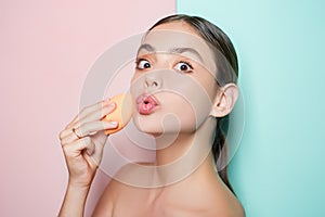 Apply concealer and cosmetic highlighter. Girl hold cosmetic applicator. Woman spreading cream on her face. Skin cream