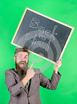 Apply for sensational educational offer. Man bearded teacher holds blackboard back to school inscription on green