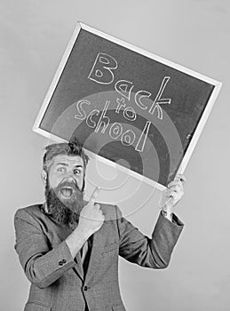 Apply for sensational educational offer. Man bearded teacher holds blackboard back to school inscription on green