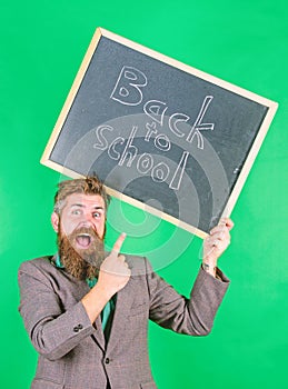 Apply for sensational educational offer. Man bearded teacher holds blackboard back to school inscription on green