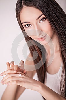 Applying cosmetic cream. A beautiful young woman applying face moisturizer. Scine care of the face and hands