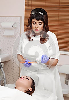 Applying cosmetic gel on the face patient.