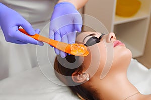 Applying cosmetic gel on the face patient.