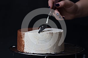 Applying cream on the cake is white on a black background