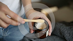 Applying dental powder to a wooden toothbrush. iroi person woman hand demonstrating