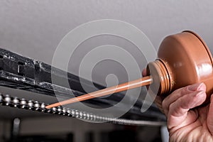 Applying a drop of oil to a chain that belongs to a garage door opener