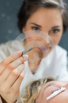 Applying false eyelashes with tweezers