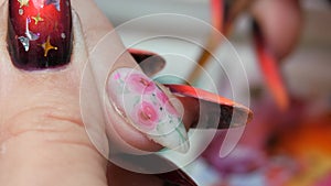 Applying a floral pattern to the nail.