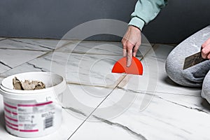 Applying fugue on ceramic tiles with a spatula.