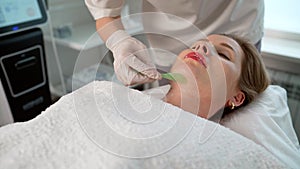 Applying gel on the face in a beauty salon. Application of cosmetic procedures using a laser device. Facial treatment of