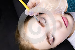 Applying hair dye to the eyebrows of the model
