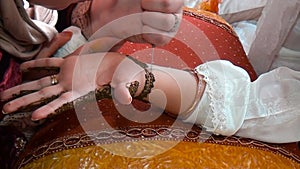 Applying a henna tattoo with a needle on a woman`s hand. Closeup shot. Morocco...Arab wedding. Moroccan traditions.